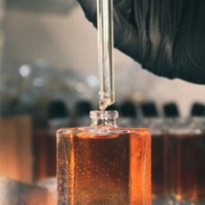 a person in a lab coat is holding a test tube with liquid in it